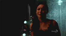 a woman in a black dress is crying in front of a global hd sign