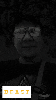 a man wearing sunglasses and a black shirt with the word beast on the bottom right
