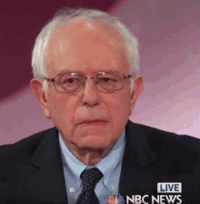 a man wearing glasses and a suit is on a live nbc news program