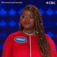 a woman wearing a red dress has a name tag that says lindsay