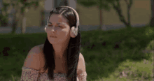 a woman wearing headphones sitting in the grass