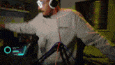 a man wearing headphones and goggles is standing in front of a microphone with the name smithashley on the screen behind him