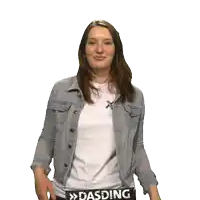 a woman wearing a white shirt and a denim jacket has a dasding sign on her back