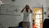 a man stands in front of a white board with a drawing of a skull