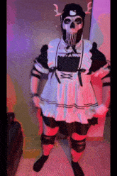 a man dressed as a maid with a skull mask on his head