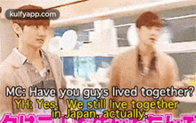 two men are standing next to each other in a room and talking about their lives together .