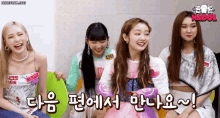 a group of girls are sitting next to each other and laughing in a room .