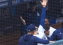 a man in a dodgers jersey stands in the dugout