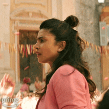 a woman in a pink shirt with the word prime on the bottom left
