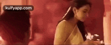a woman in a white dress is standing in front of a man in a red room .
