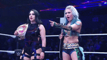 two women in a wrestling ring with a w logo on the bottom right