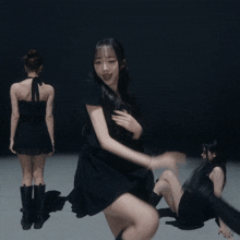 a girl in a black dress is surrounded by other girls