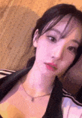 a close up of a woman wearing a necklace .