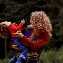 a woman is holding a baby in her arms