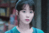 a close up of a woman 's face with a ponytail and a necklace