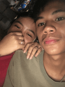 a man and a woman are posing for a picture and the woman is wearing a ring on her finger