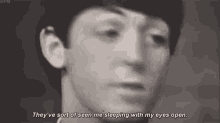a black and white photo of a man 's face with the words `` they 've seen me sleeping with my eyes open '' .