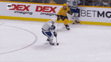 a hockey player with the number 23 on his jersey stands on the ice