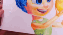 a person is holding a drawing of a girl with blue hair