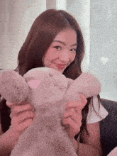 a woman is sitting on a couch holding a stuffed bunny rabbit .