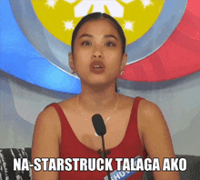 a woman in a red tank top is speaking into a microphone with the words na-starstruck talaga ako written below her