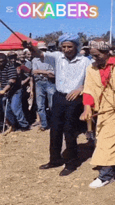 a man in a blue turban is dancing in front of a crowd with the words okabers on the bottom