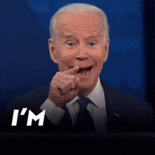 a man in a suit and tie says " i 'm coming " in white letters