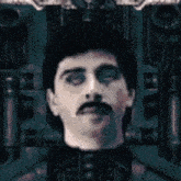 a man with a mustache is standing in a dark room
