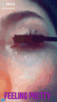 a tiktok video of a woman applying mascara with the caption feeling pretty momento