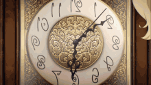 a gold and white clock with the hands on the numbers 1 and 2