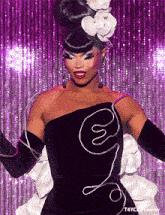 a woman wearing a black and white dress with a flower in her hair