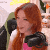 a woman with red hair is wearing headphones in front of a microphone that says minecraft on the back