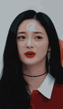 a close up of a woman wearing a choker necklace and red lipstick
