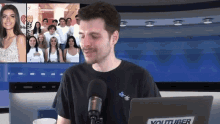 a man sitting in front of a youtuber laptop