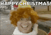 a man wearing a wig and a hat is smiling and says happy christmas .