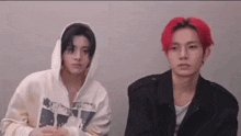 two men with red hair are sitting next to each other and looking at the camera .
