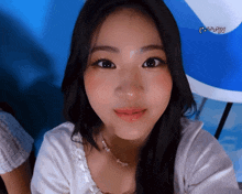 a close up of a woman 's face with a blue background and a smiley face on the bottom
