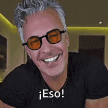 a man wearing sunglasses and a black shirt is smiling and says eso