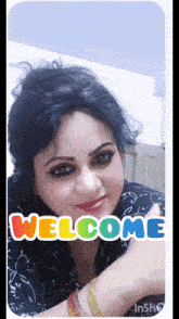 a woman is giving a thumbs up with a welcome sticker on her face