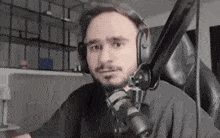 a man wearing headphones and a microphone is sitting in front of a computer .