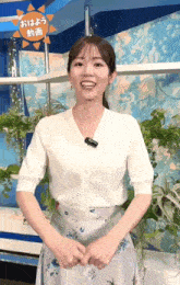 a woman wearing a white cardigan and a floral skirt