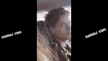 a man is sitting in a car wearing headphones and a scarf .