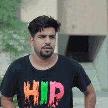 a man with a beard is wearing a black shirt that says hip