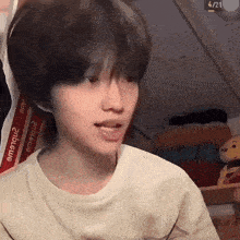 a young boy with short hair is making a funny face in a room .
