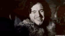 a close up of a man 's face with a fur coat around his neck .