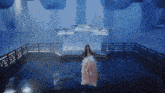 a girl in a pink dress is sitting on a swing