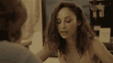 a woman looking at herself in a mirror with a necklace on