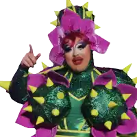 a drag queen is wearing a green and purple outfit with spikes