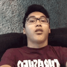 a man wearing glasses and a t-shirt that says thrash