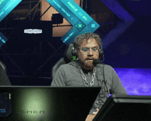 a man wearing headphones sits in front of a monitor that says space soft on it